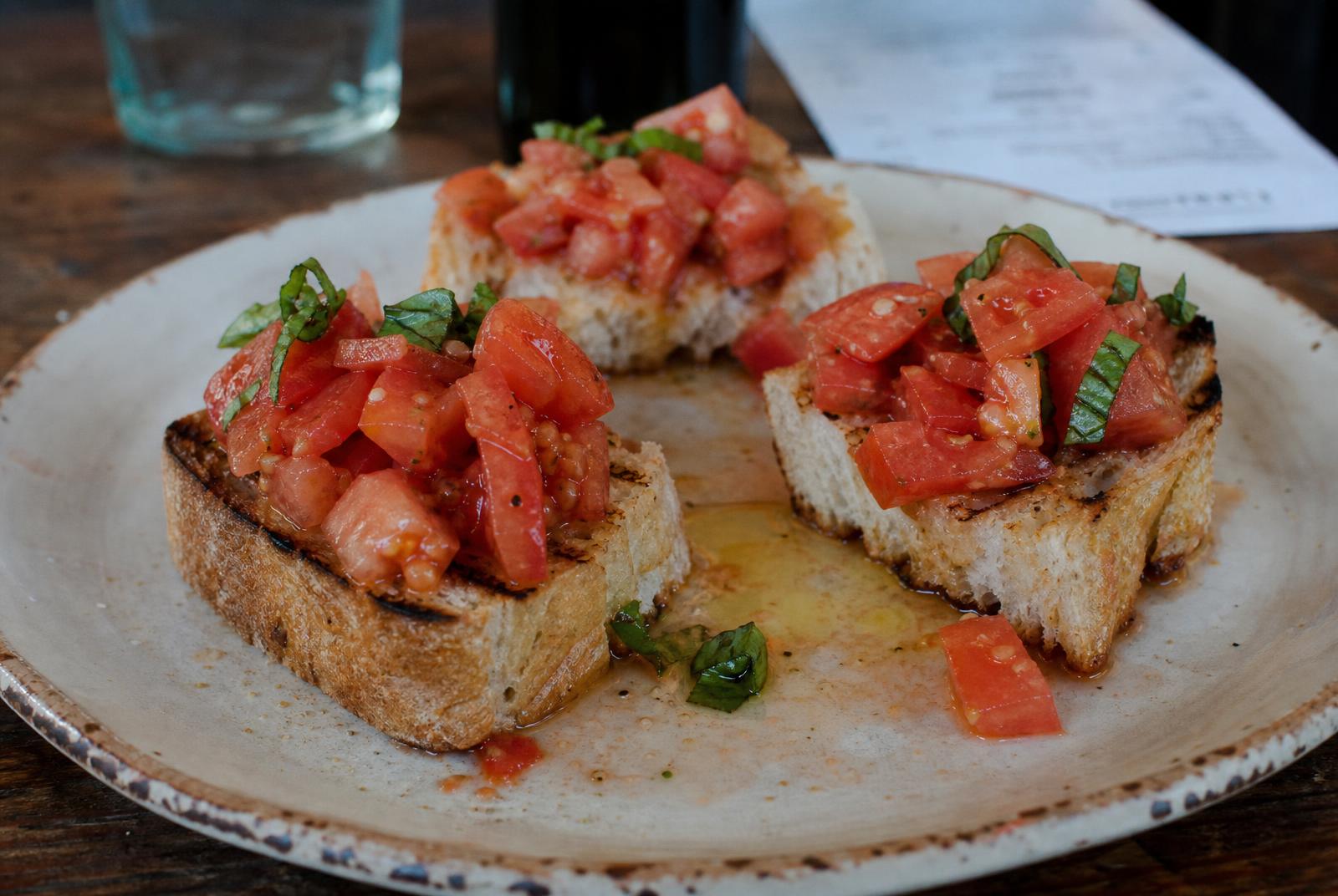 Toasted ciabatta topped with macerated tomatoes and basil